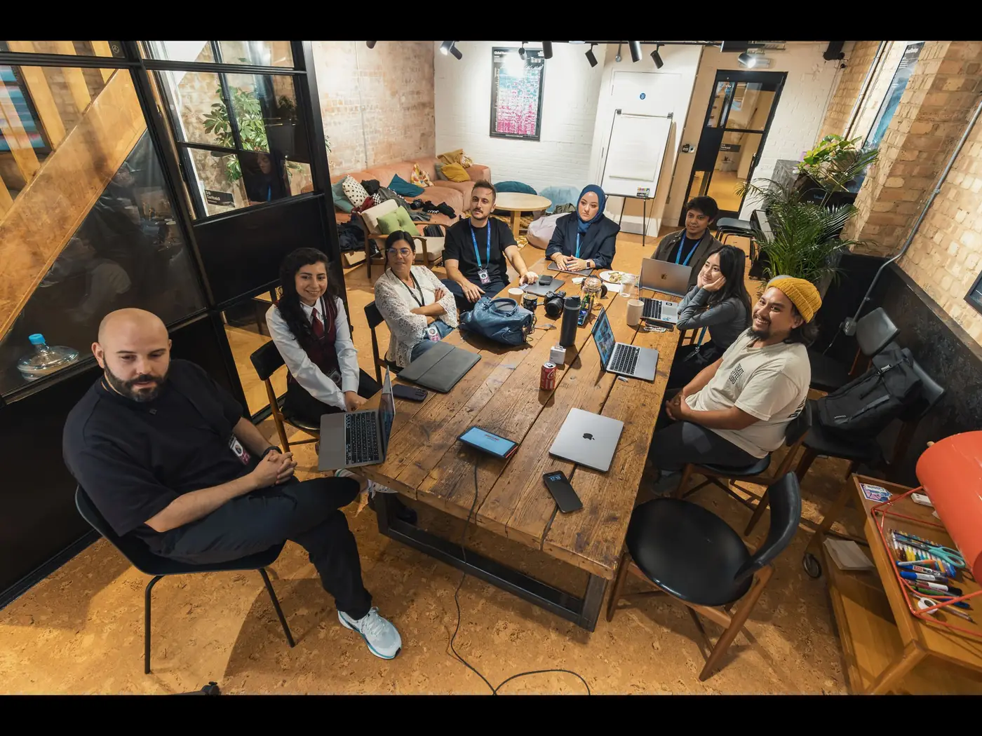 Gruppo di persone riunite attorno a un tavolo di lavoro in uno spazio condiviso