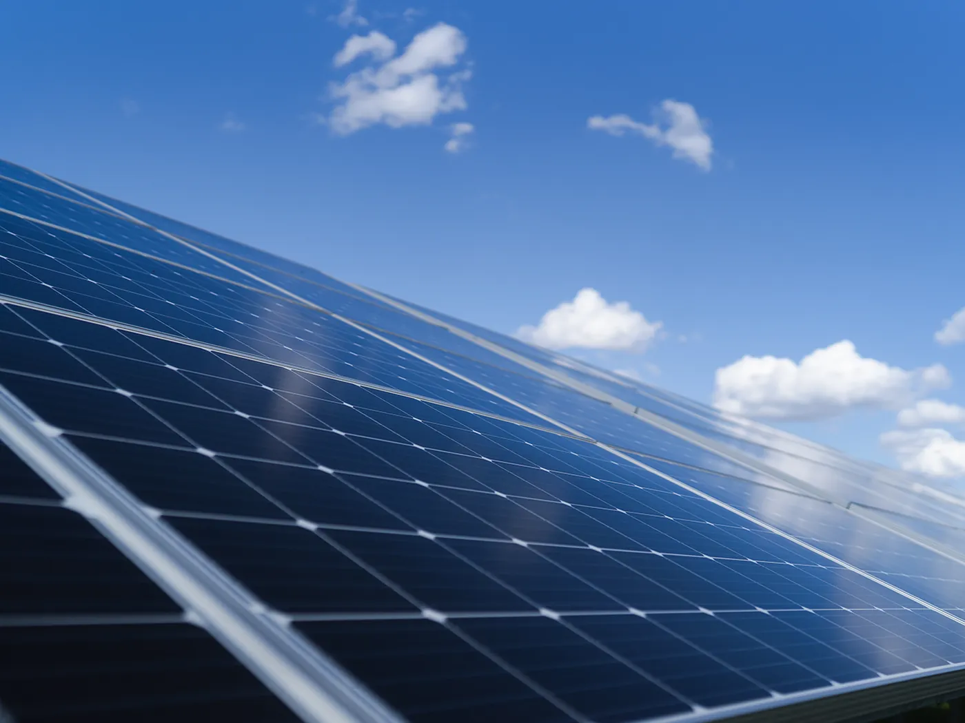 File di pannelli fotovoltaici visti di scorcio contro un cielo sereno